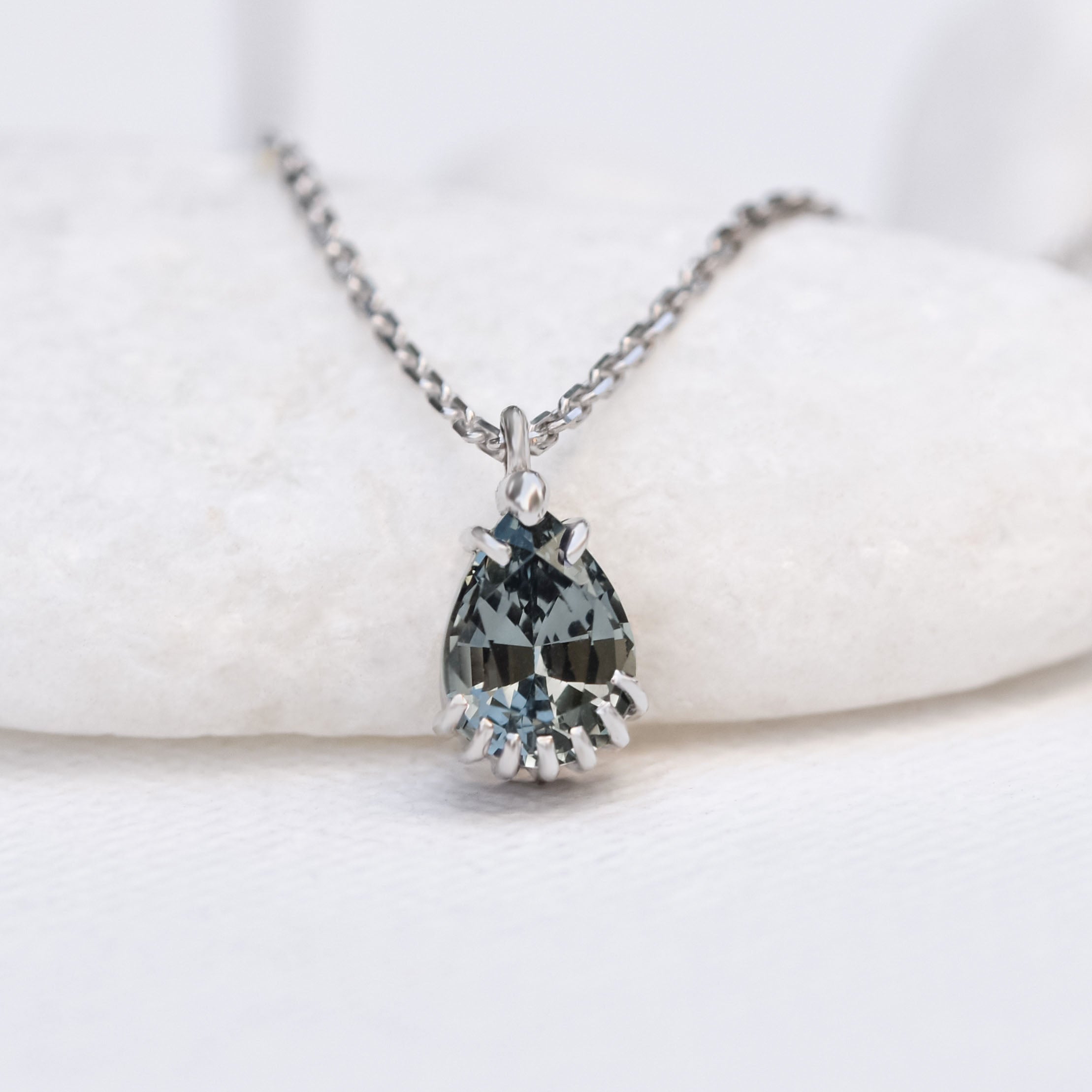 14k white gold gemstone necklace featuring a pear cut greenish grey spinal stone pendant