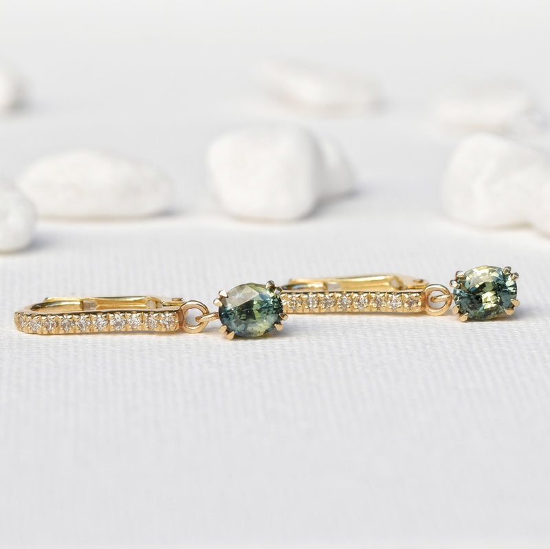 stone drop earrings with two oval yellow-green sapphire stones on elegant 10 diamonds pave setting 14k yellow gold band